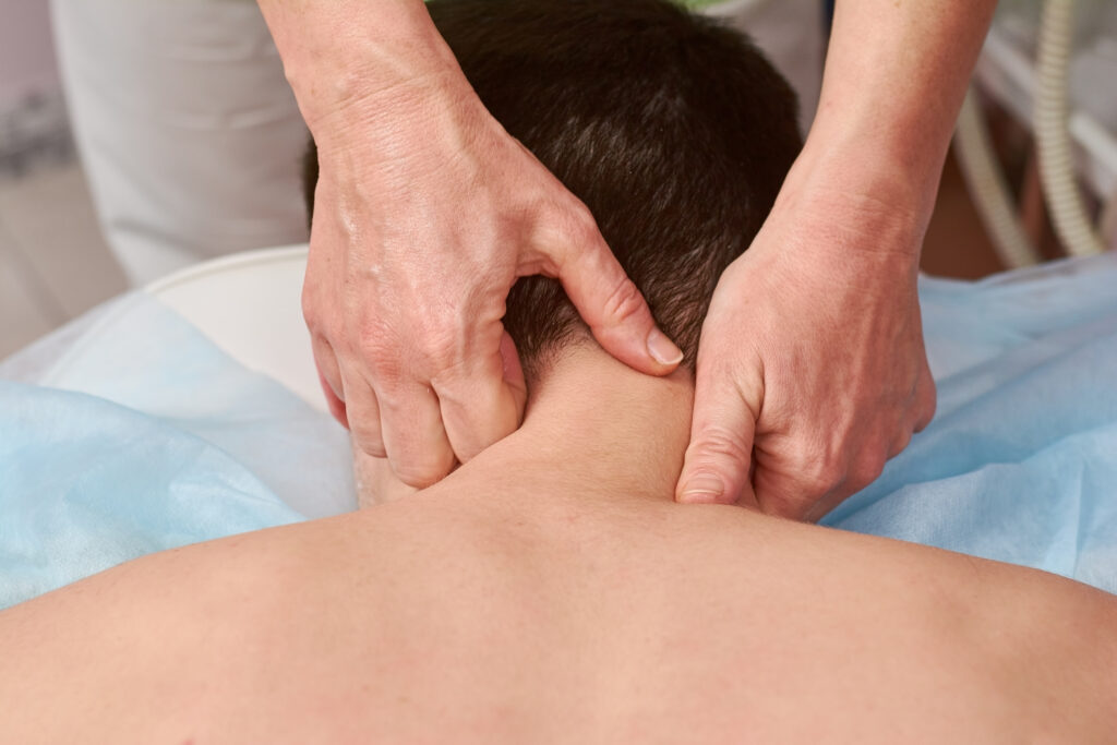 Therapeutic massage therapist releasing tight shoulder knots and head pain triggers.